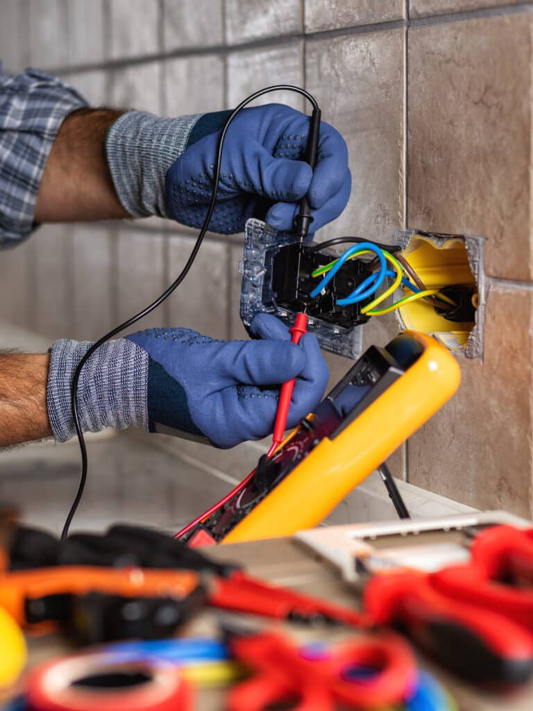 Electrician at work with safety equipment on a residential electrical system. Electricity.